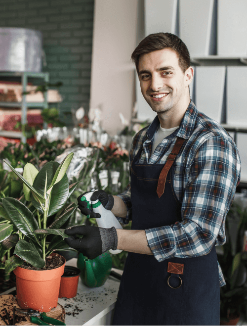 smiling-man-spraying-plants-garden-center (1) smiling-man-spraying-plants-garden-center (1)